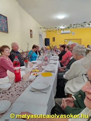 Az egybegyűltek a terített sztal mellett.