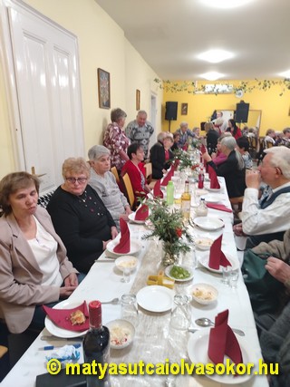 A bál résztvevői az asztalok körül.