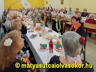 Az olvasókör terme a megterített asztalokkal, mellette a résztvevő tagok.