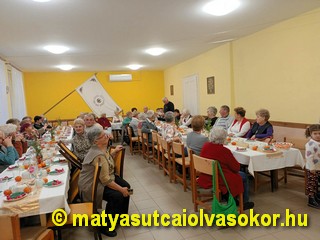 Az olvasókör terme a megterített asztalokkal, mellette a résztvevő tagok.