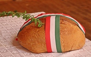 A képen egy nemzeti színű szalaggal átkötött kenyér látható.